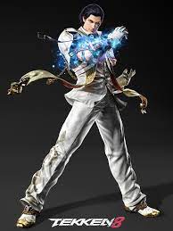 A promotional image of Claudio Serafino, a character from Tekken 8, standing confidently. Claudio is depicted with slicked-back dark hair and sharp features. He is wearing a white, long-sleeved, button-up shirt with silver embellishments on the collar, a pair of white trousers, and silver-tipped shoes. His left hand is raised and is glowing with a blue, mystical energy, suggesting the activation of a special power.